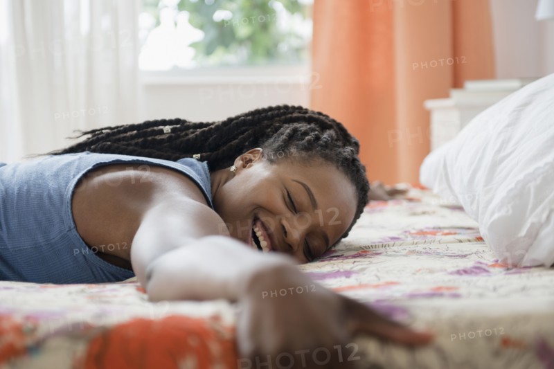 Black woman laying on bed