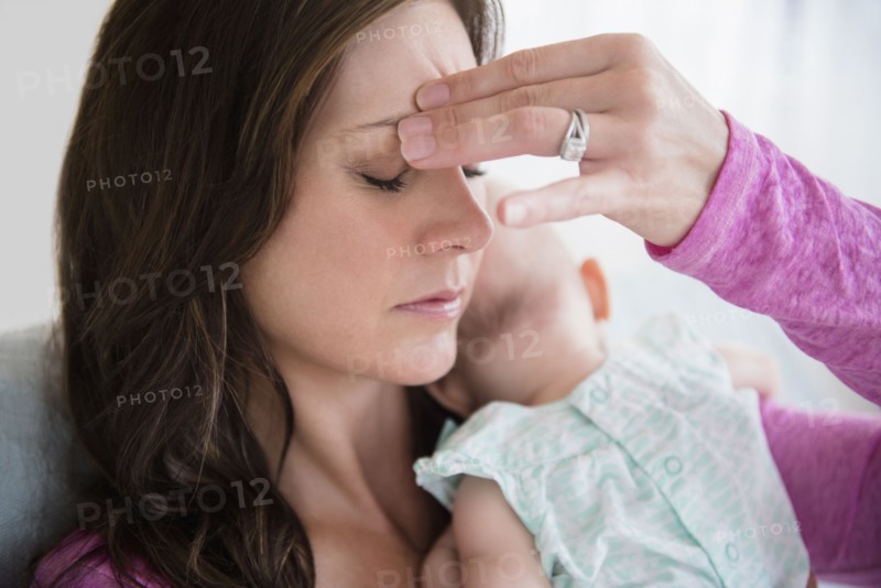 Stressed mother pinching her forehead