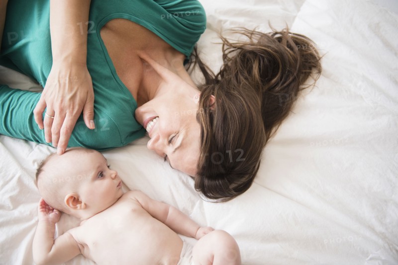 Mother laying with baby daughter