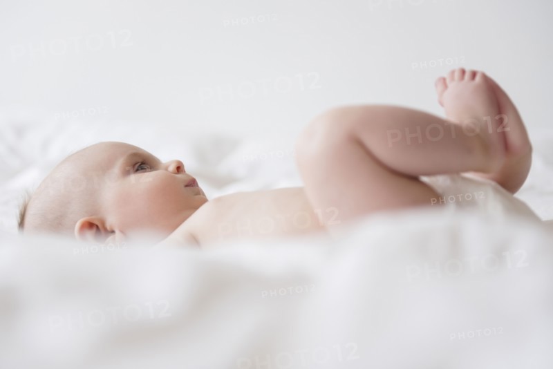 Caucasian baby girl laying on bed