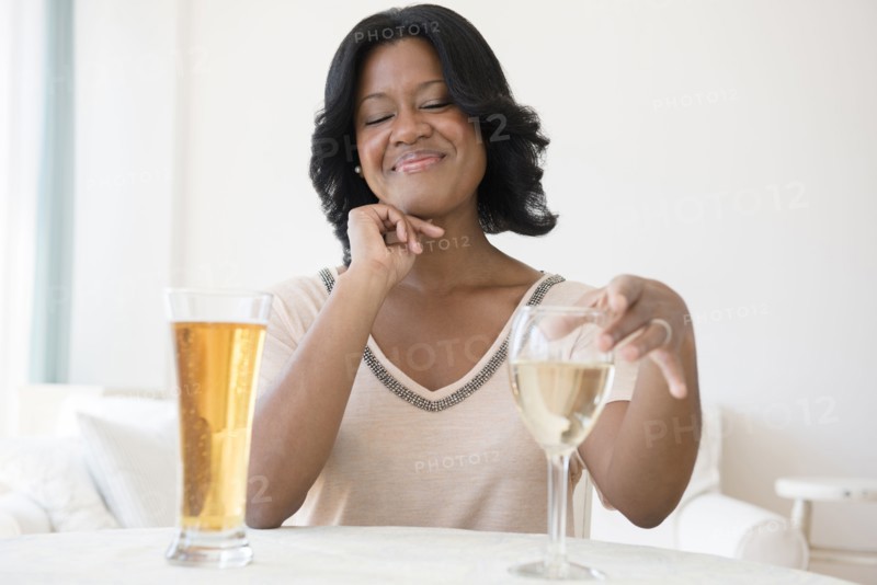 Black woman choosing between white wine and beer