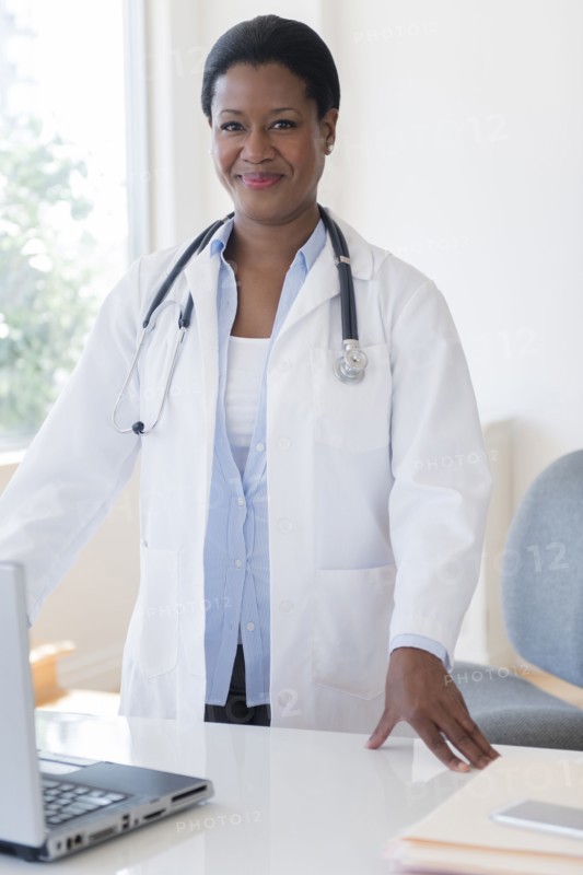Black doctor standing at desk