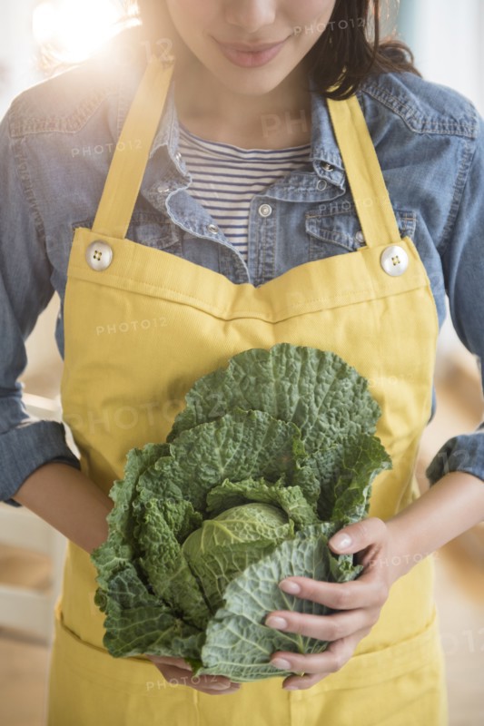 Hispanic woman holding head of lettuce