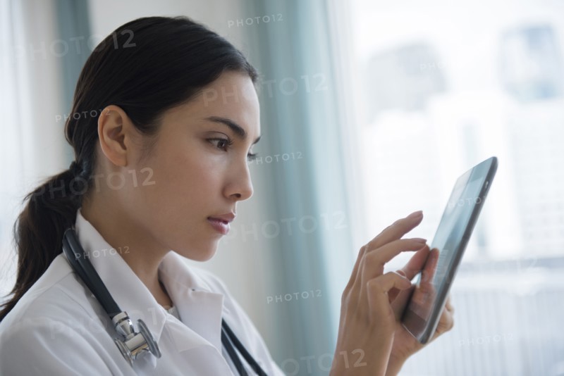 Hispanic doctor using digital tablet