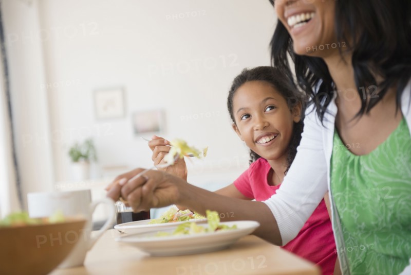 Mother and daughter eating salad
