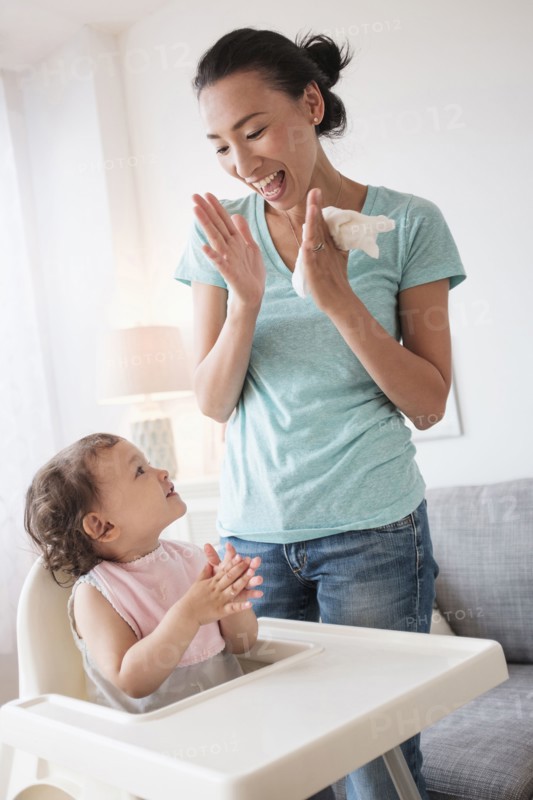 Mother clapping with baby daughter