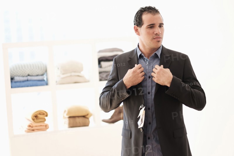 Hispanic man trying on suit in store
