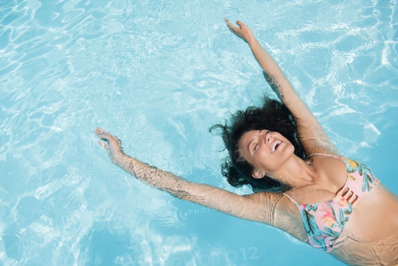 Caucasian woman floating in swimming pool