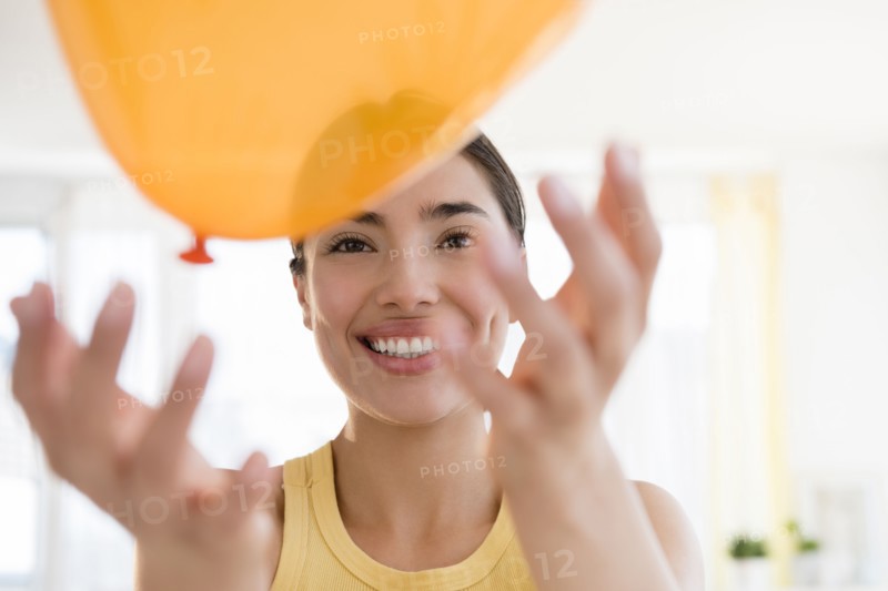 Hispanic woman playing with balloon