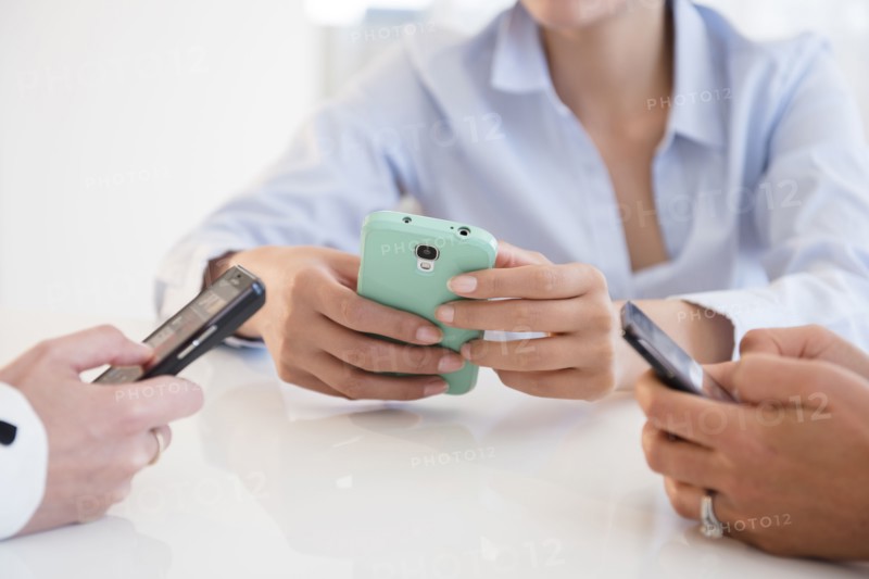 Business people using cell phones in office