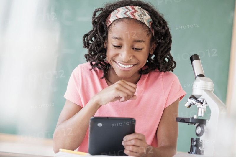Black student using digital tablet in science class