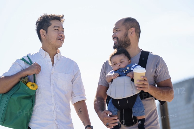 Gay fathers doing errands with baby son