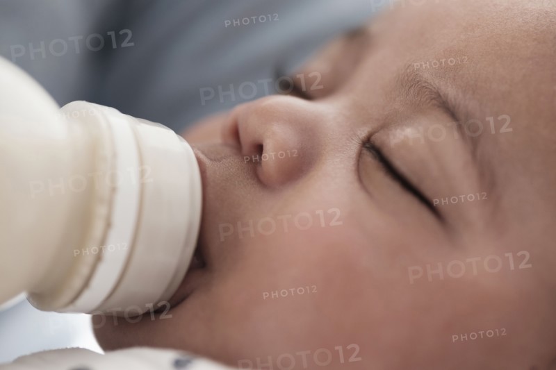 Close up of mixed race boy bottle feeding
