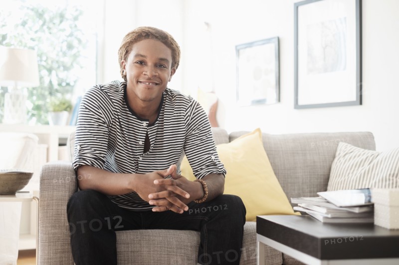 Mixed race man sitting on sofa