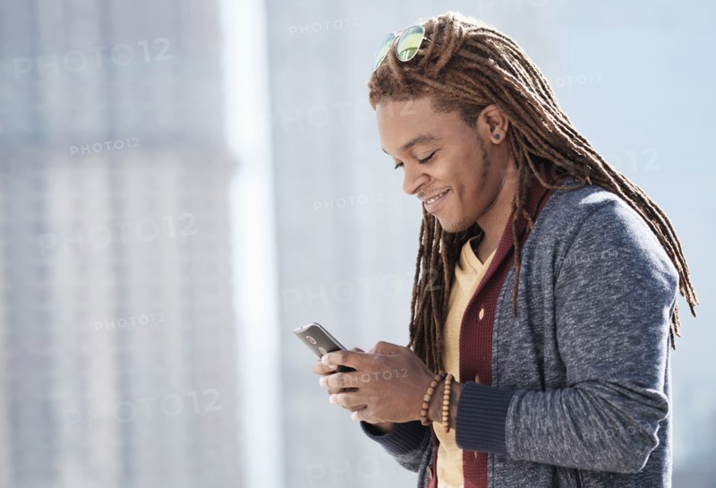 Mixed race man using cell phone outdoors