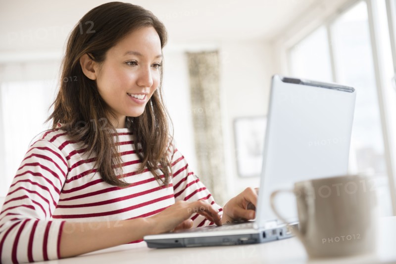 Mixed race woman using laptop