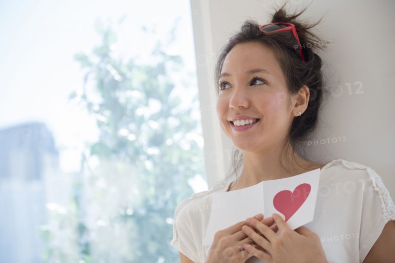 Mixed race woman holding Valentine card