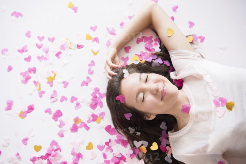 Mixed race woman playing in confetti