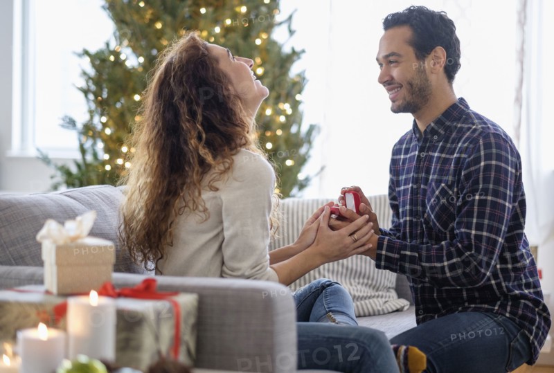 Man proposing to girlfriend on sofa