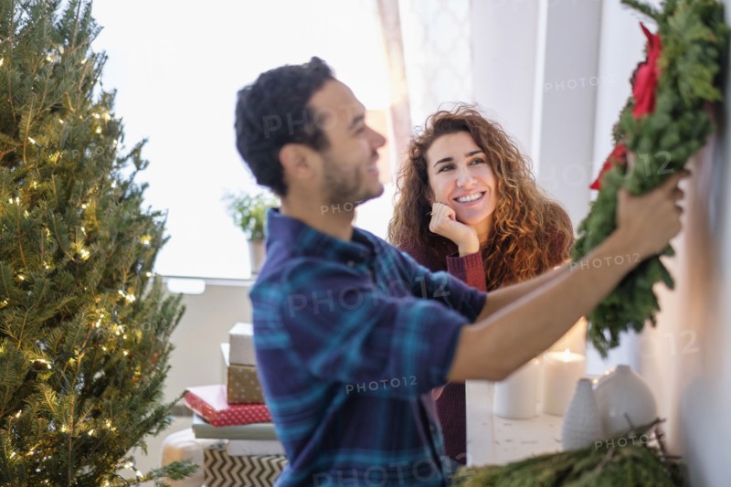 Couple hanging Christmas wreath