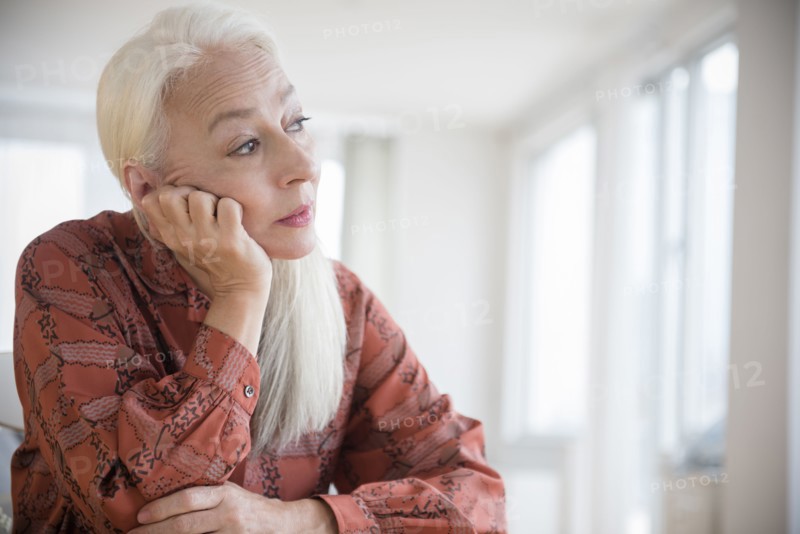 Caucasian woman sitting with chin in hand