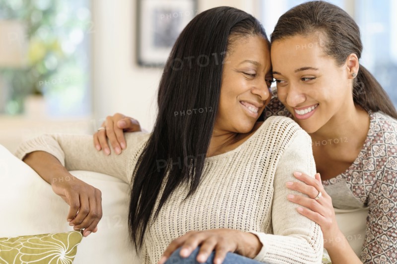 Mother and daughter hugging in living room