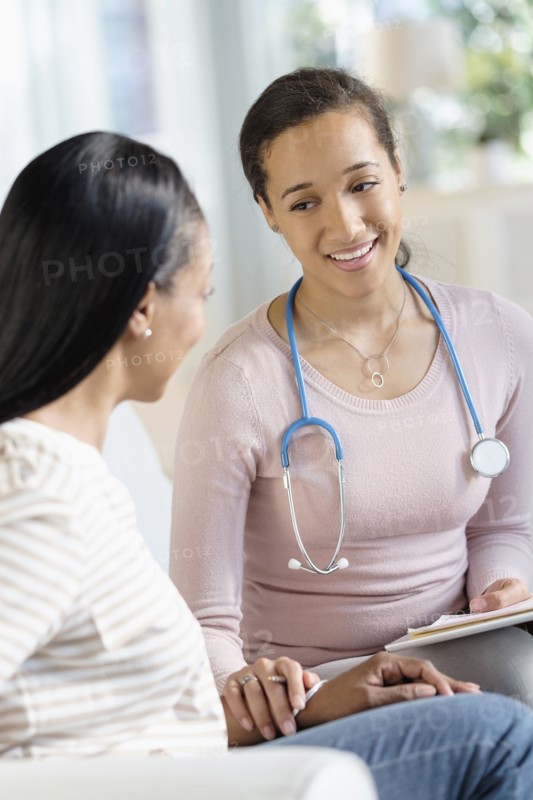 Doctor comforting patient in living room