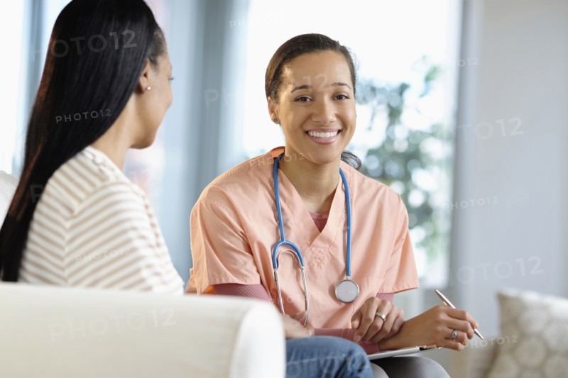 Nurse smiling with patient in living room