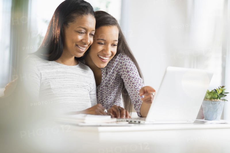 Mother and daughter using laptop