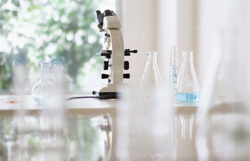 Microscope and beakers in laboratory