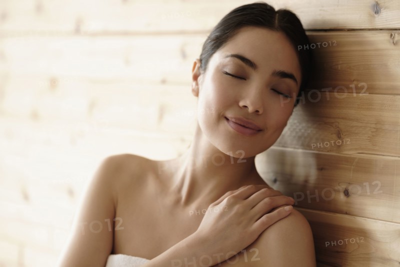 Hispanic woman relaxing in sauna