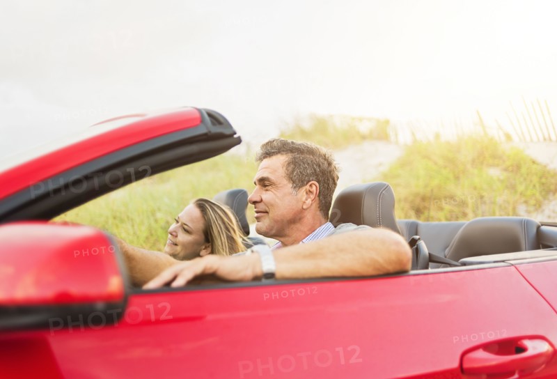 Caucasian couple driving convertible