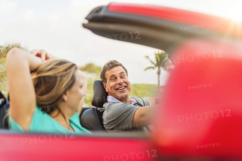 Caucasian couple driving in convertible
