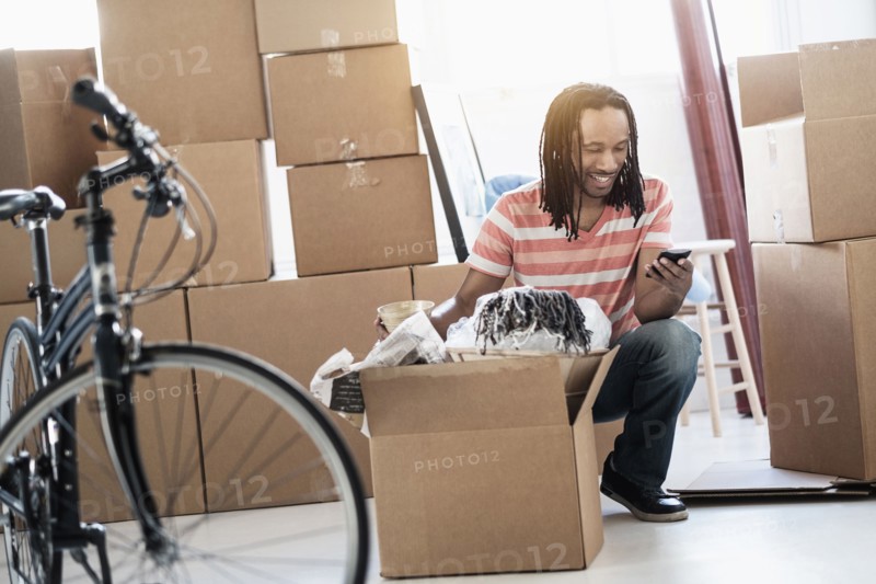 Black man unpacking boxes in new home