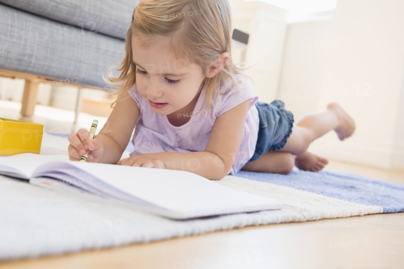 Caucasian girl doodling on floor