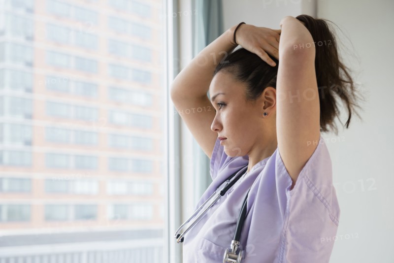 Nurse tying her hair up in hospital