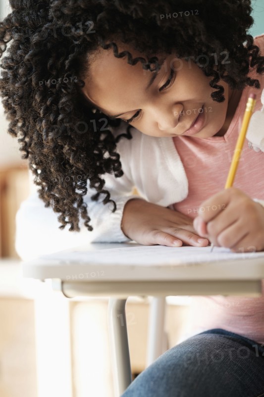 African American student writing in classroom
