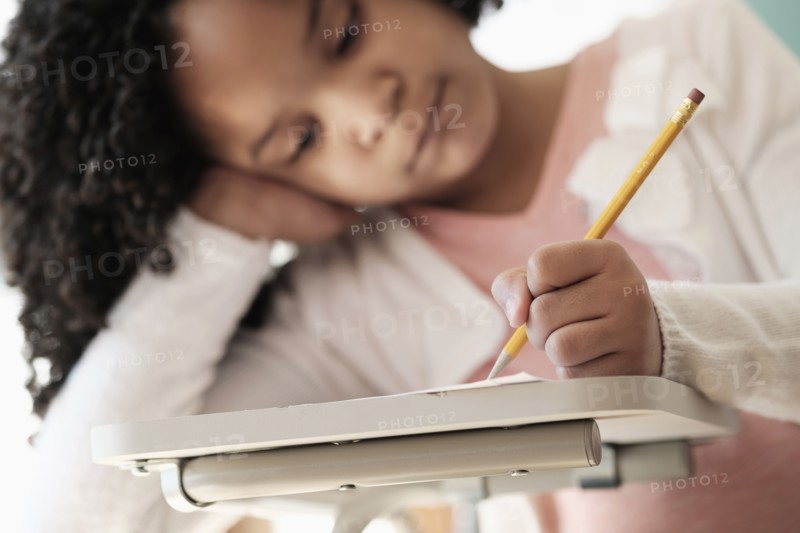 African American student writing in classroom