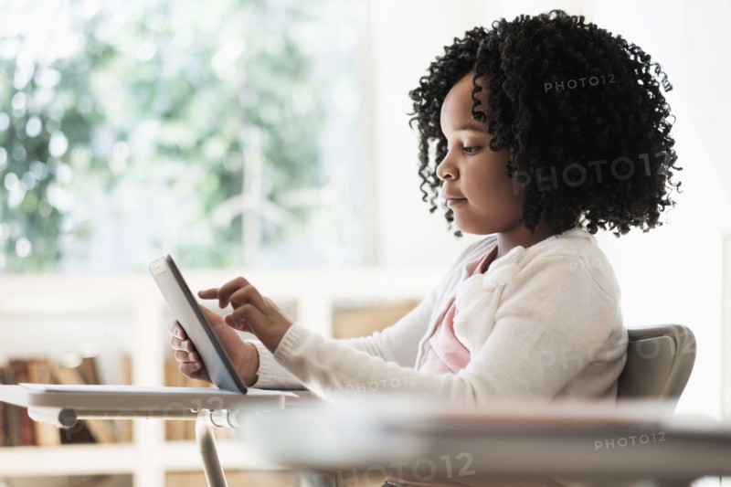African American student using digital tablet in classroom