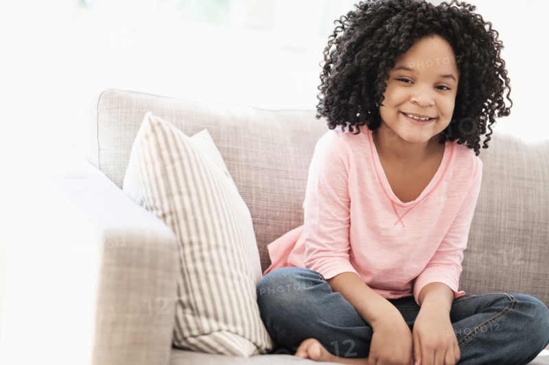 African American girl smiling on sofa