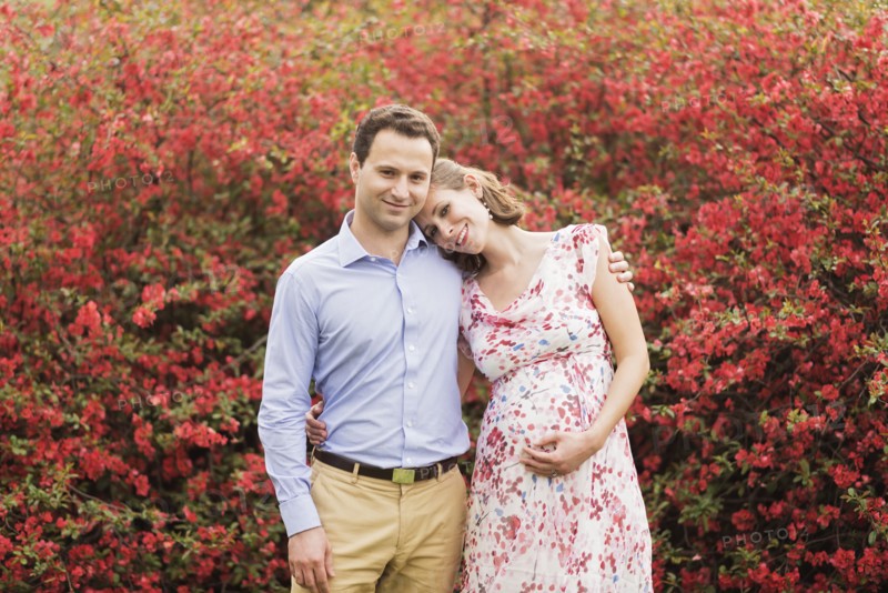 Pregnant Caucasian couple hugging outdoors