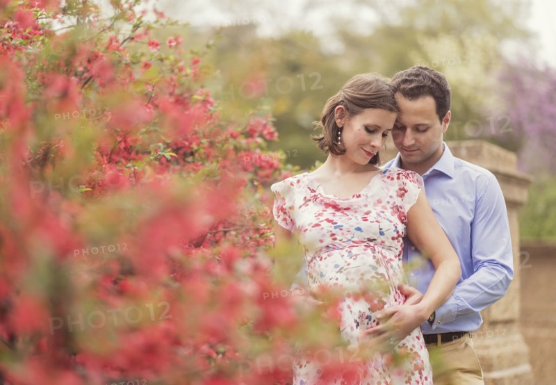 Pregnant Caucasian couple hugging outdoors