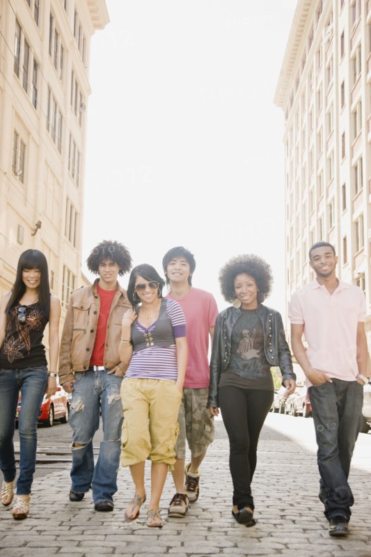 Multi-ethnic friends walking down urban sidewalk