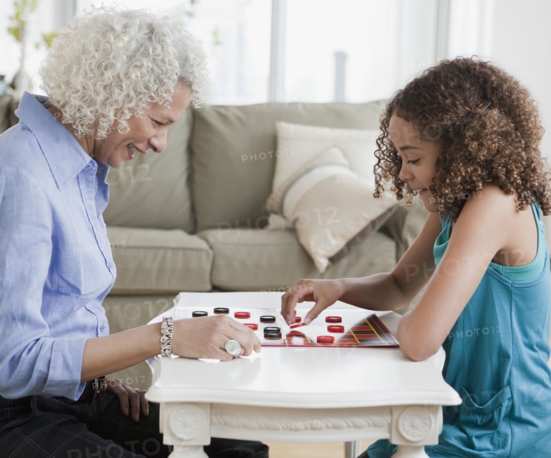 Grandmother and granddaughter playing checkers