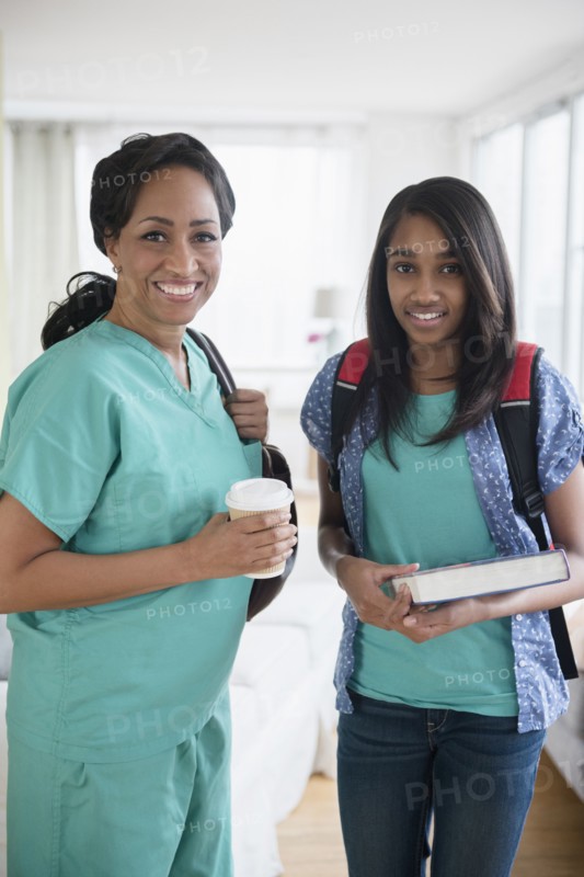 Smiling nurse and daughter leaving house in morning