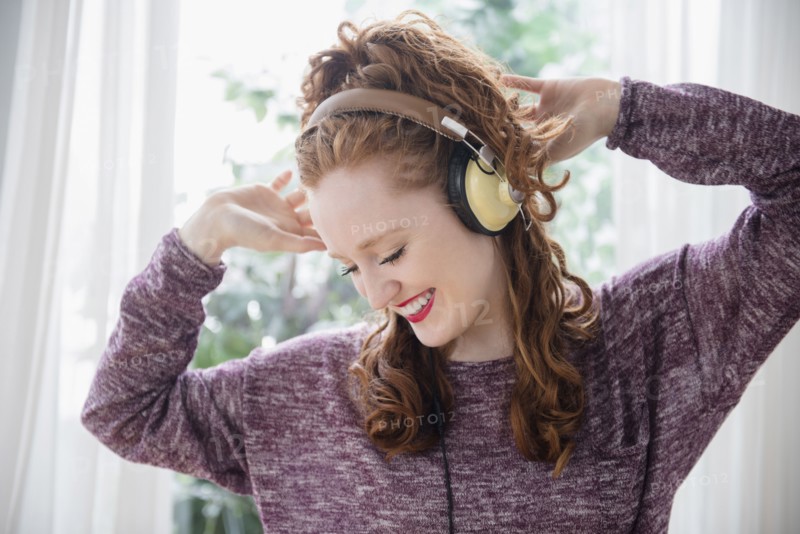 Caucasian woman listening to headphones and dancing