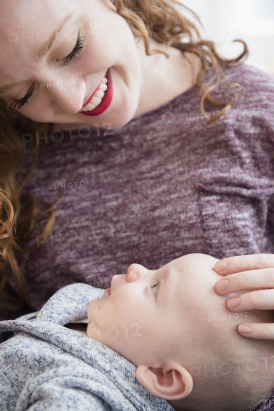 Caucasian woman holding baby son in lap