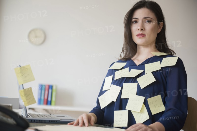 Blouse of stressed Caucasian businesswoman covered with adhesive notes