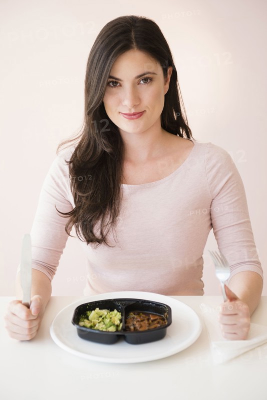 Caucasian woman preparing to eat TV dinner