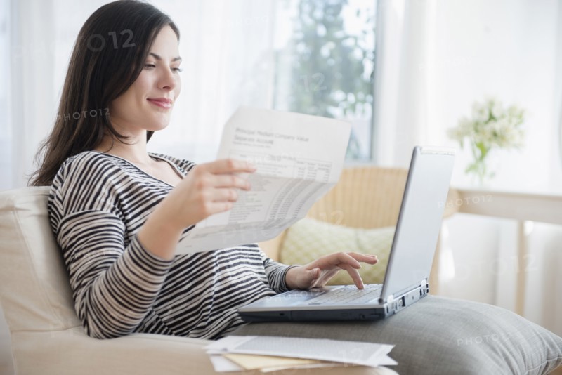 Caucasian woman paying bills using laptop